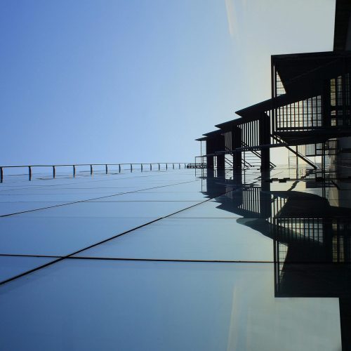A striking glass skyscraper reflecting blue skies, showcasing modern architecture's elegance.